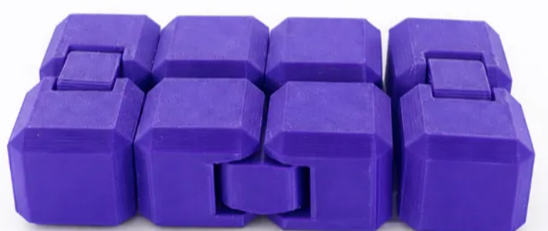 Purple hinged cube fidget unfolded into a rectangular shape on a white background